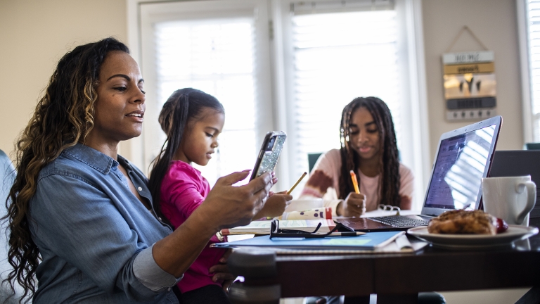 Mother working from home while daughters homeschool. Mother working from home while daughters homeschool.