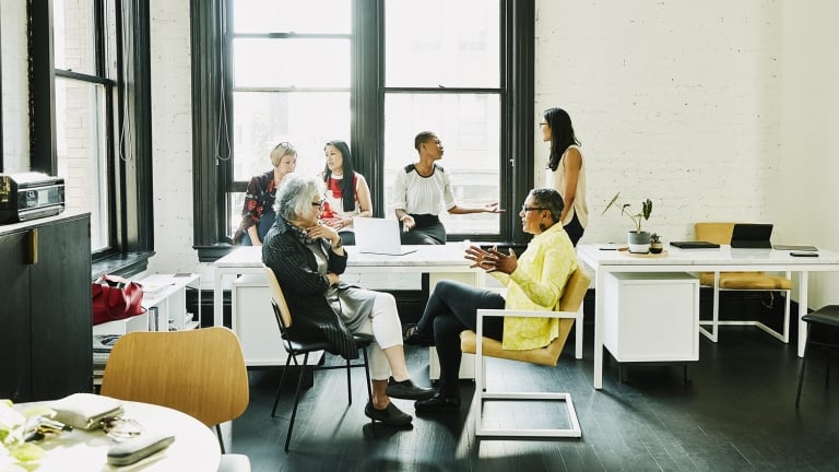 Female coworkers in discussion during team meeting in creative office.