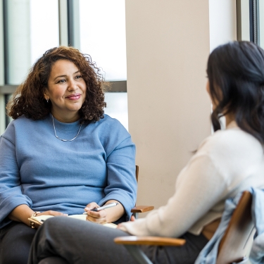 Female human resources rep smiles encouragingly at female employee. Female human resources rep smiles encouragingly at female employee.