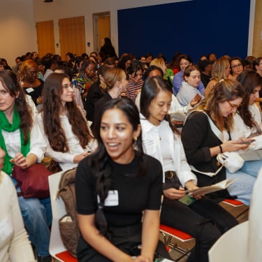 Auditorium of women talking.