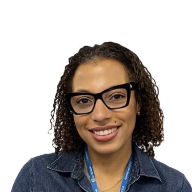 Katia Barnave smiling, wearing glasses, a dark denim shirt, and a blue lanyard, against a plain white background. Katia Barnave smiling, wearing glasses, a dark denim shirt, and a blue lanyard, against a plain white background.