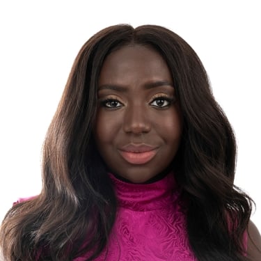 Esosa Ighodaro with long, wavy dark hair wears a bright pink, sleeveless, high-neck top and looks directly at the camera against a white background.